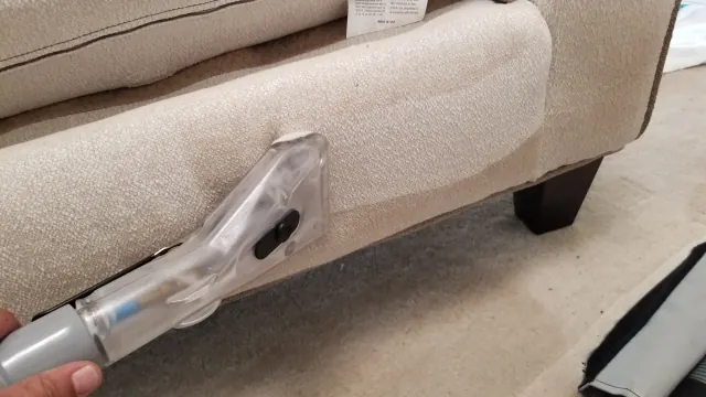 Upholstery cleaning along the base of a sofa