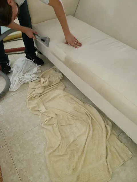Cleaning a sofa cushion on a drop cloth